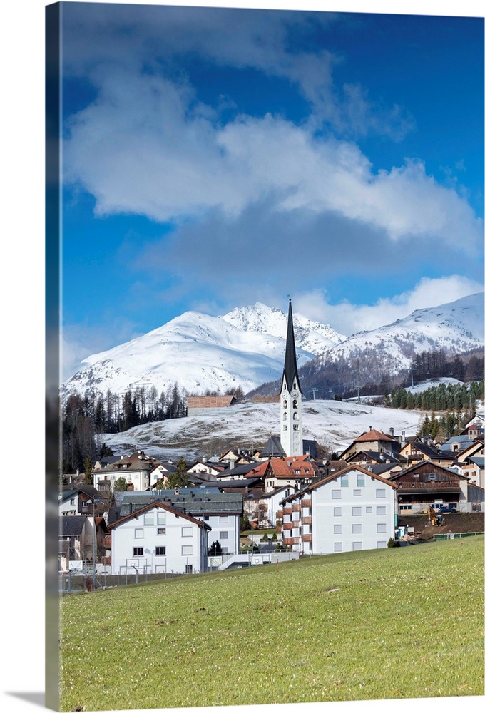 View of the alpine village of Zuoz surrounded by snowy peaks in spring, Maloja, Canton of Graubunden, Engadine, Swiss Alps...
