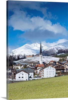 View of the alpine village of Zuoz surrounded by snowy peaks in spring