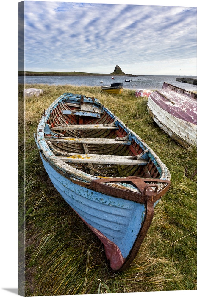 View towards Lindisfarne Castle with an old blue and red fishing boat in the foreground, Lindisfarne (Holy Island), Northu...