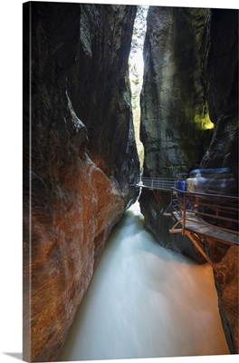 Water of creek flows in the narrow limestone gorge carved by river, Switzerland