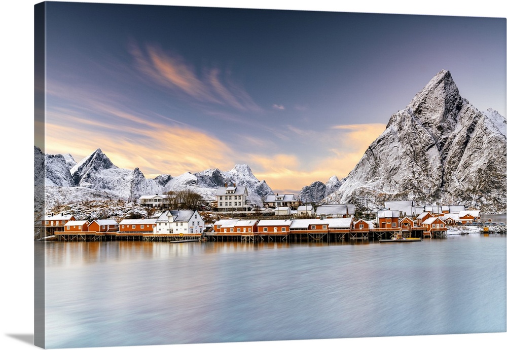 Winter sunset over snowcapped mountains and Sakrisoy village by the frozen sea, Reine, Nordland, Lofoten Islands, Norway, ...