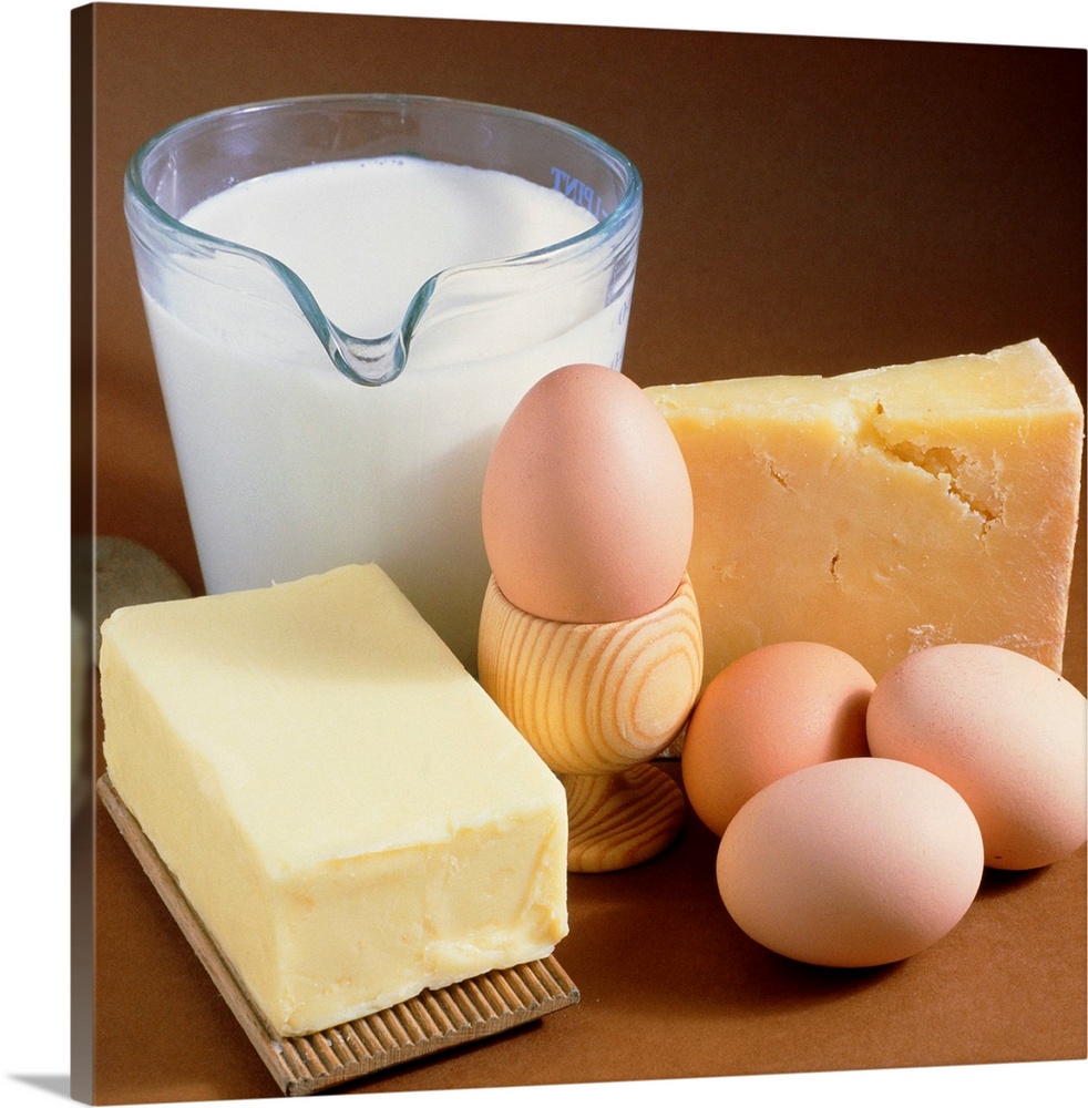 Dairy food products. A selection of food; clockwise from upper left they are: milk, cheese, eggs and butter. Cheese is mad...