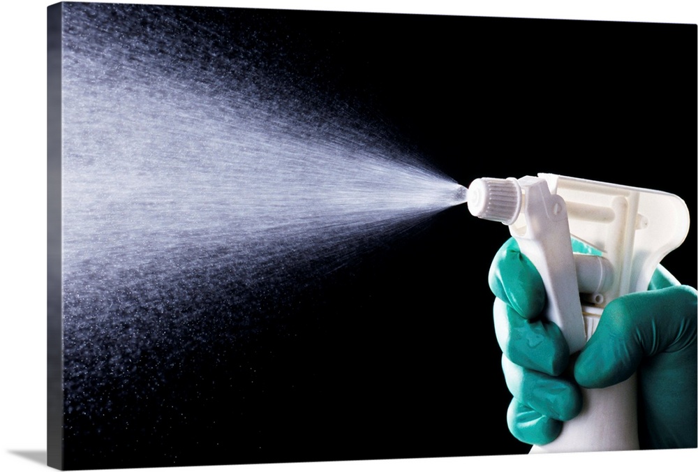 Cleaning. Liquid being ejected from a plastic spray bottle.