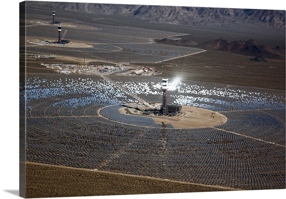Concentrating solar power plant. Heliostat (mirrors with sun-tracking motion) arrays and receiver towers at a concentratin...
