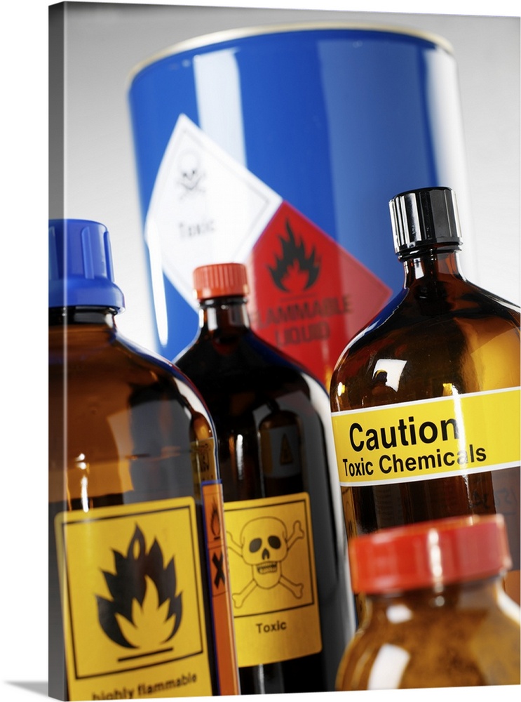 Hazardous chemicals. Containers labelled with chemical hazard warning signs. The signs seen here warn about toxic chemical...