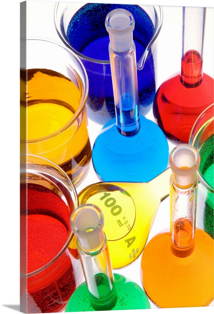 Laboratory glassware. Beakers and volumetric flasks containing coloured liquids.