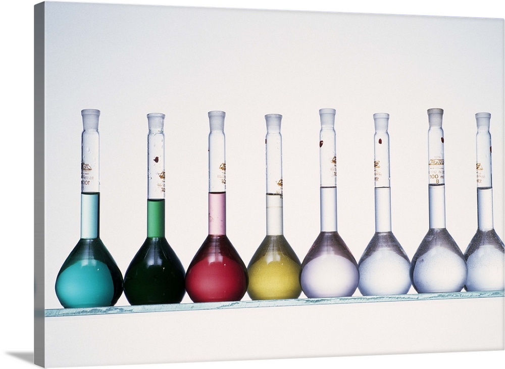 Metal compound solutions. The volumetric flasks contain solutions of an assortment of metals. The five at left are salts o...