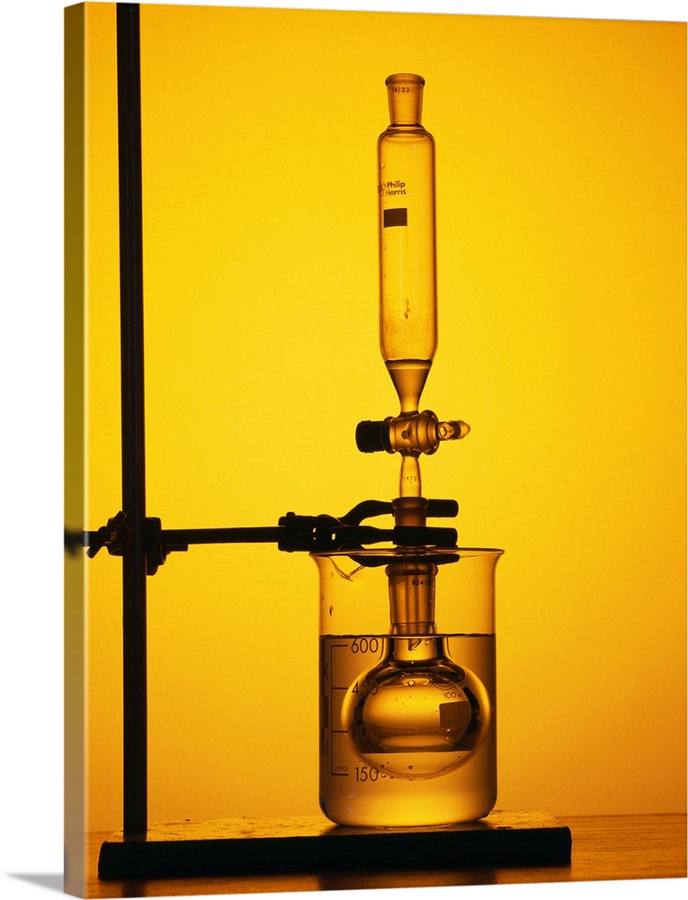 Organic synthesis. Apparatus used to manufacture nitrobenzene. The round-bottomed reaction flask is held in a beaker of co...