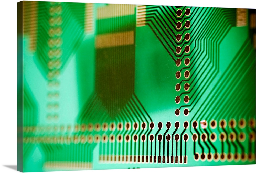 Printed circuit board (PCB), showing the holes into which component connections are inserted and soldered. The metal etchi...