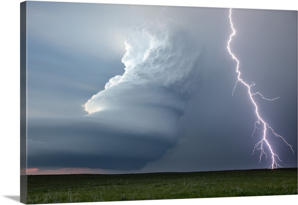 Supercell thunderstorm and lightning strike over rural Nebraska, USA. A supercell thunderstorm is a severe long-lived stor...