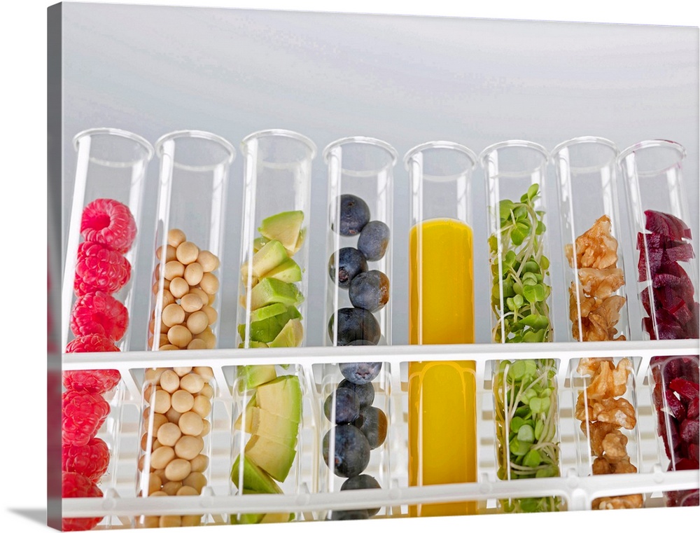 Superfoods. Test tubes containing a variety of superfoods. From left to right are: raspberries, soya beans, avocado, blueb...