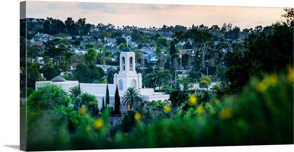 The Newport Beach California Temple is surrounded by lush green grass, shrubs, and trees. It was dedicated in 2003 by Duan...