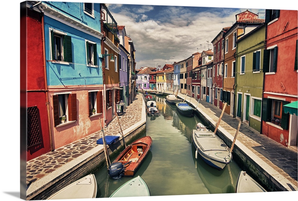 This landscape photograph shows a narrow canal lined with vividly colorful houses.