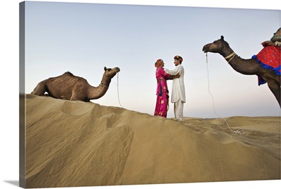 Bride and groom with camels in sand dunes, Rajistan, India
