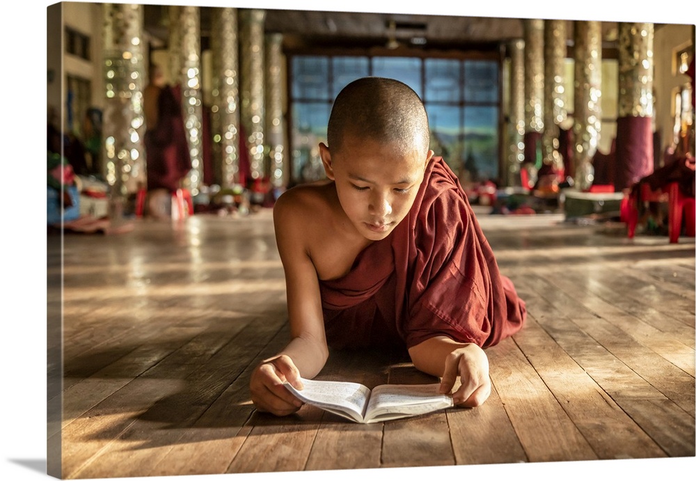 Burmese monk reading in his monastery
