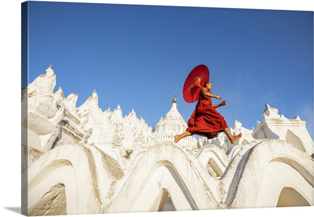 Burmese monk with parasol walking at his monastery in Mandalay