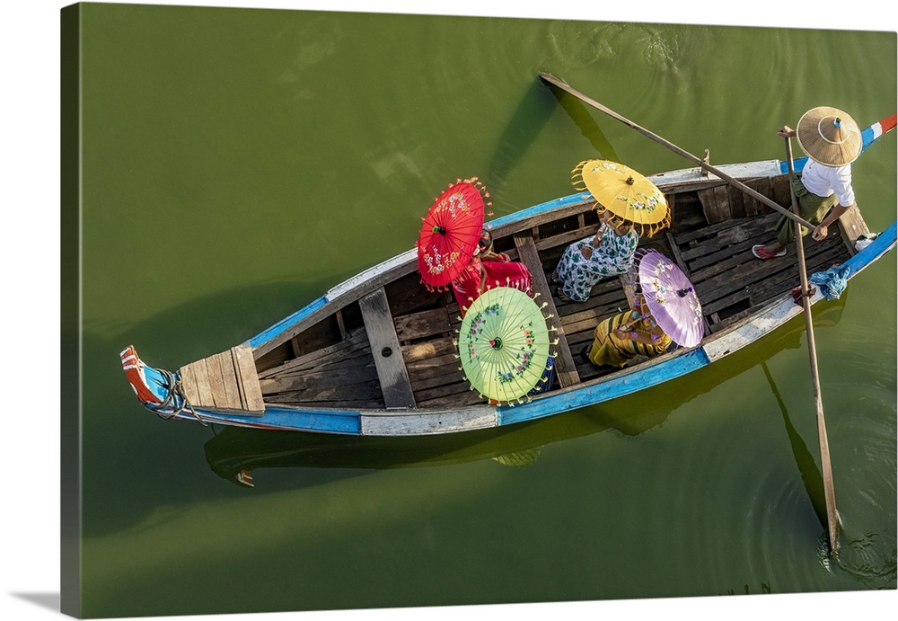 Burmese women with umbrellas boating by the Ubein Bridge in Burma