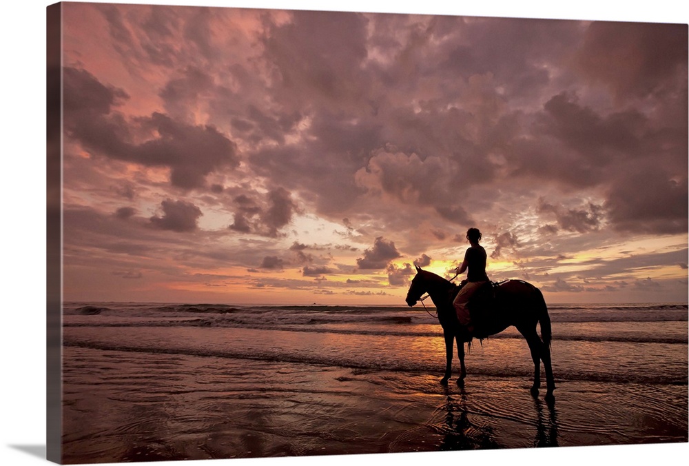 Colorful sunset on the beach with horse and rider