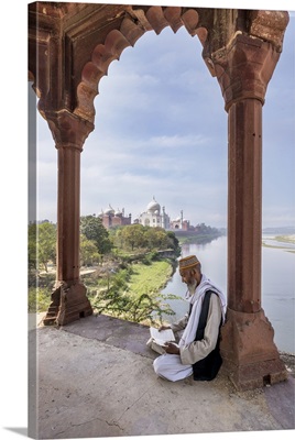 Holy Man  In Prayer And Reading By The Taj Mahal