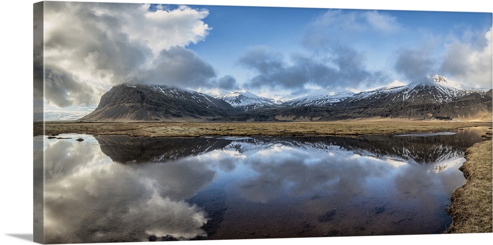 Snow covered mountain panorama reflecting in a lake in Iceland.