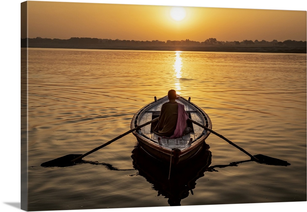 Man rowing a longtail boat on the Ganges River, Varinasi, India