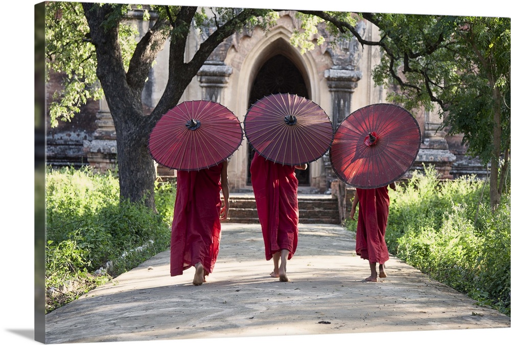 monks walking with parasols in monastery, Bagan, Burma