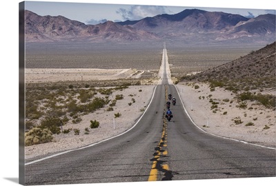Motorcycles riding long road into Death Valley National Park