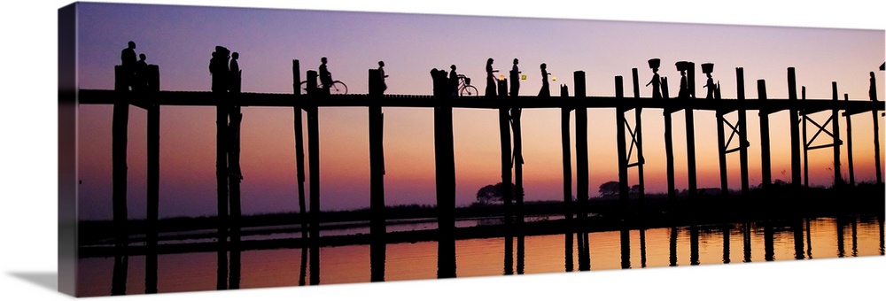 People walking across the UBein bridge at sunset in Mandalay, Burma