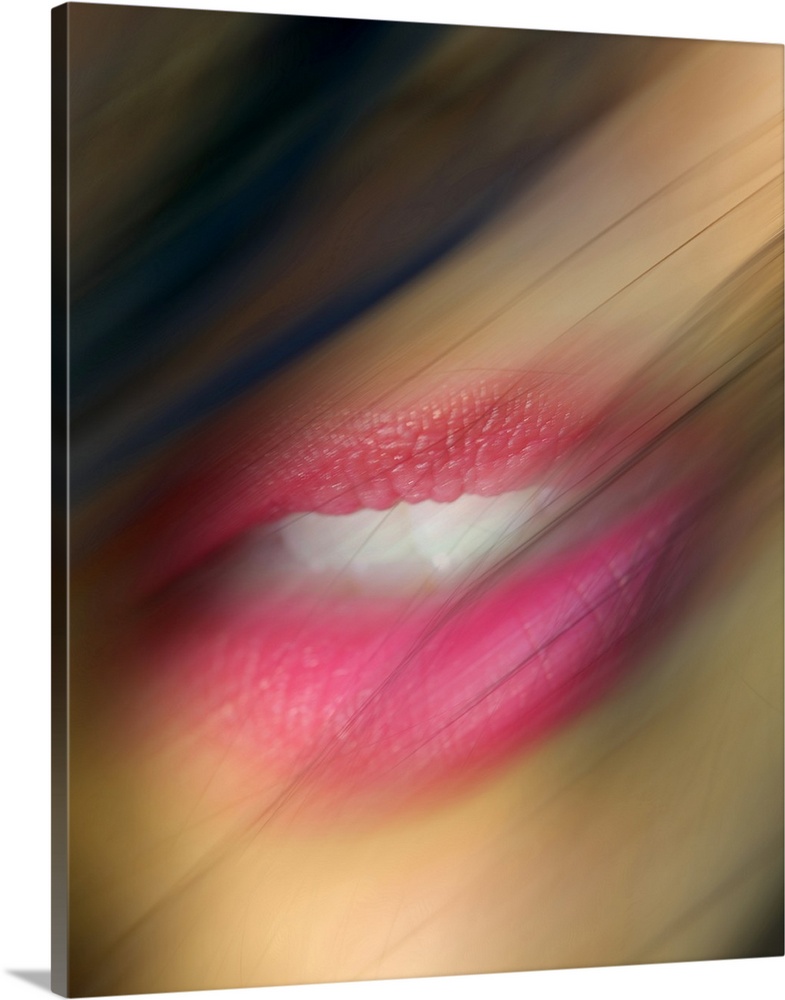 Hair blows in front of a woman's lips that are photographed closely and appear slight blurry.