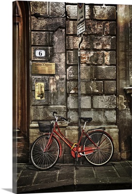 Red bicycle by stone wall, Florence, Italy