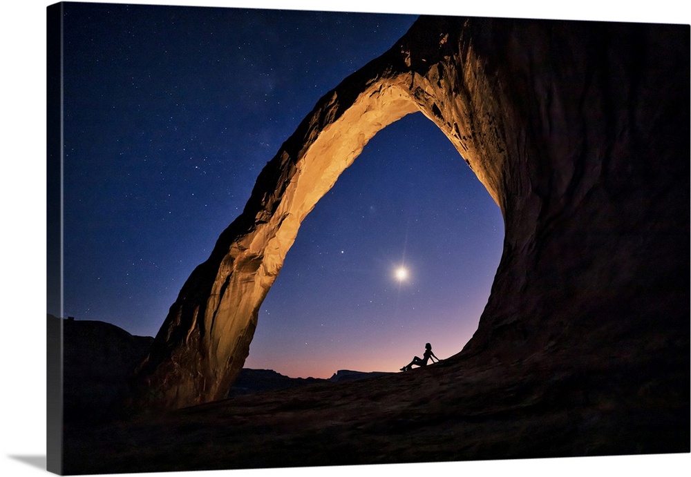 Silhouette of a woman under Corona Arch in Moab, Utah