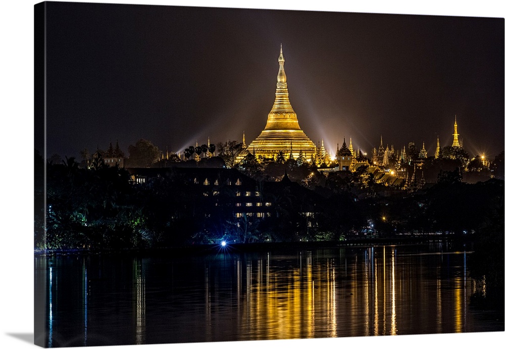 The Shwedagon Pagoda reflecting in the water after dark in Yangon.