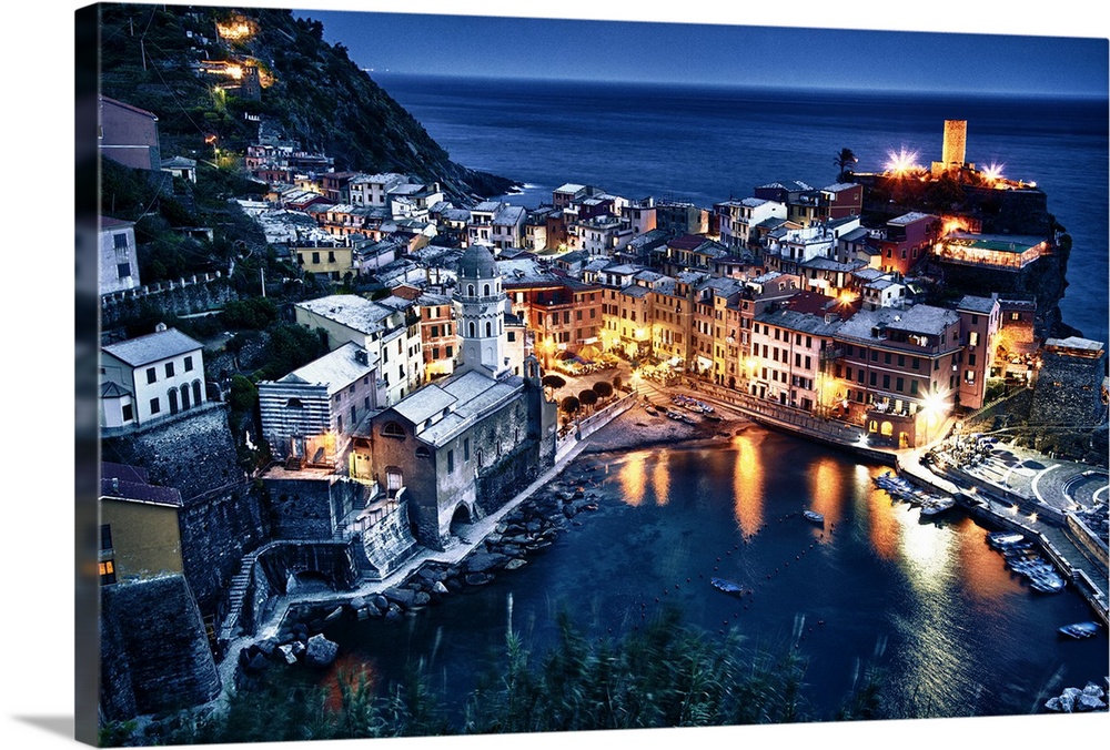 Aerial view of a seaside town in Cinque Terre, Italy at night with houselights lighting up the night. Boats, the sea, clif...