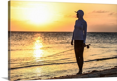 A Female Angler Looking For Her Quarry At Sunset In Belize