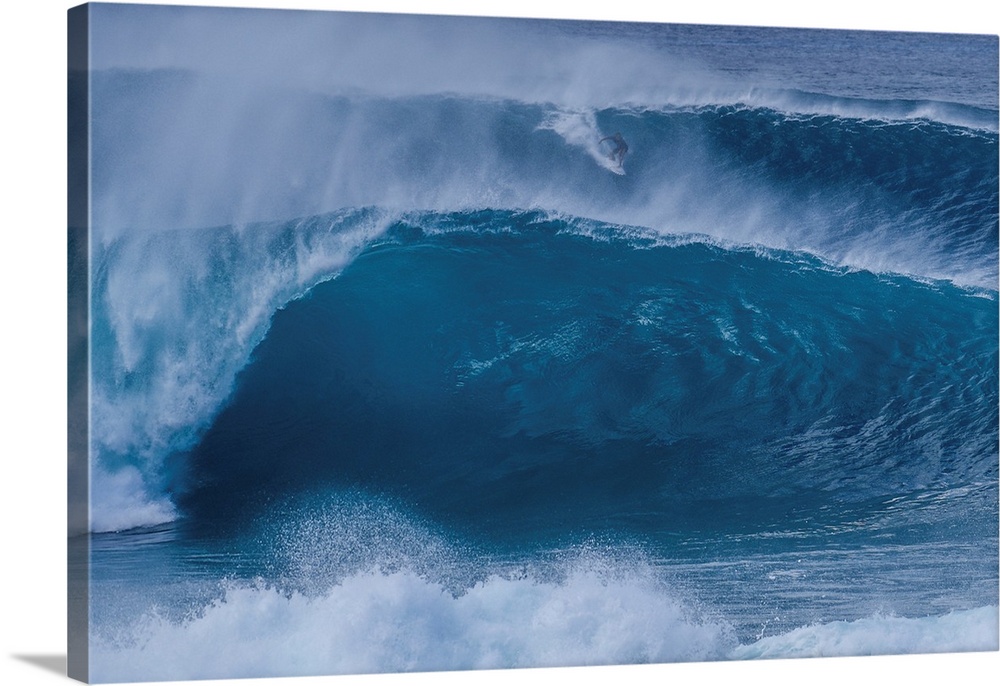 A surfer rides a wave from the outer reef at the legendary pipeline surf spot on Oahu's north shore.