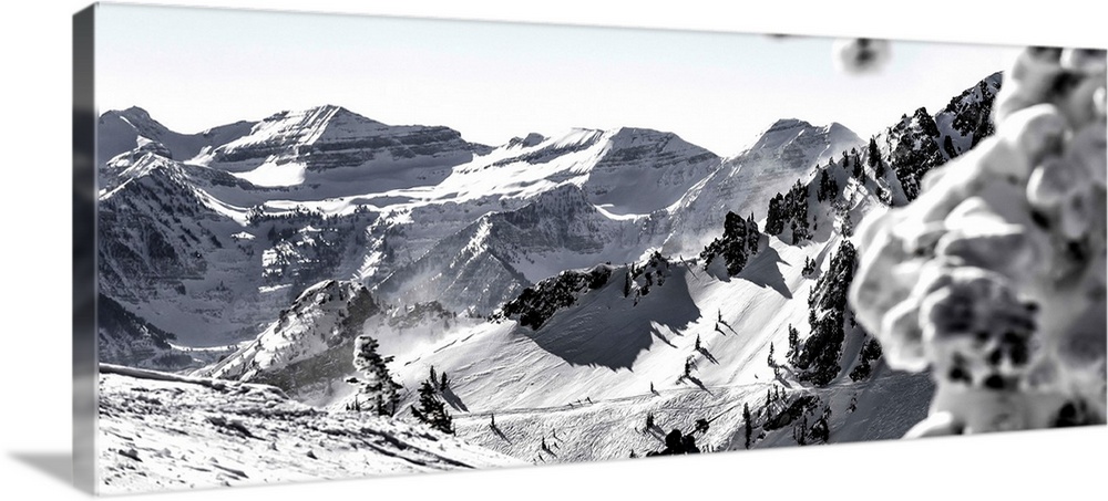 Black and white landscape photograph of the Wasatch Range in Utah with a skier hiking up in the middle.