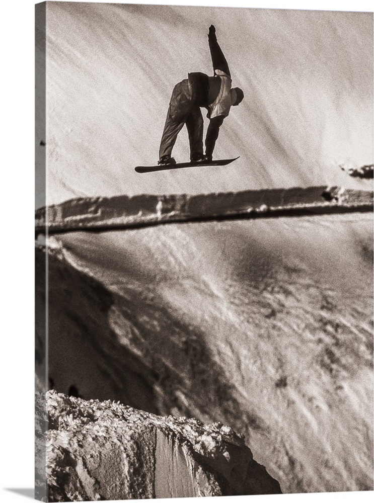 Black and white image of Tracy Latzen grabbing his snowboard in hte air at Donner Summit, California.