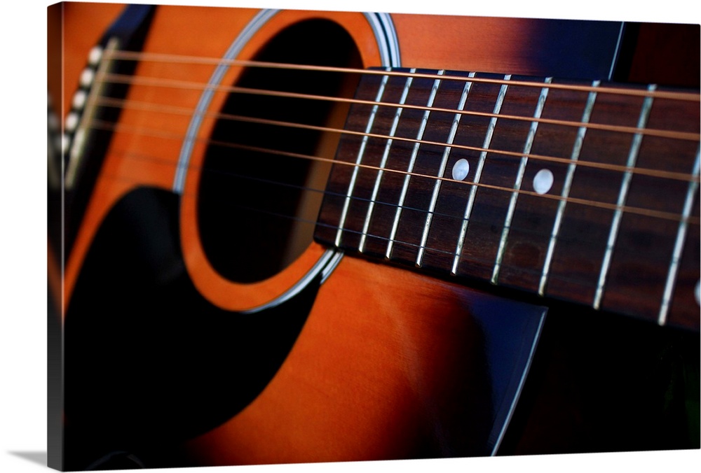 Close up of a six string acoustic guitar.
