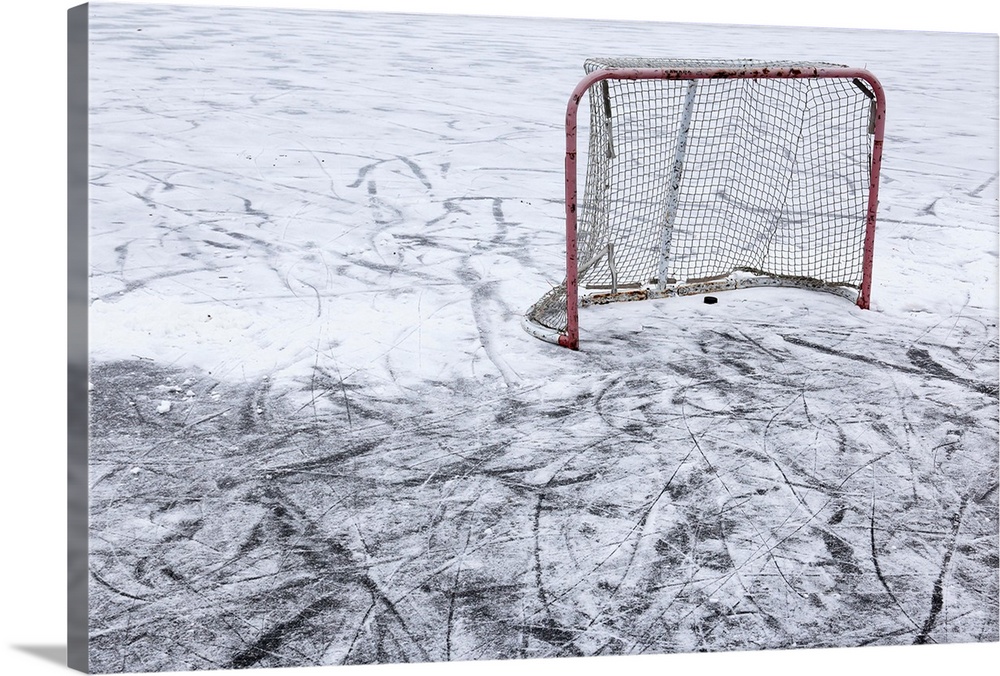 An ice hockey net on an outdoor pond rink.