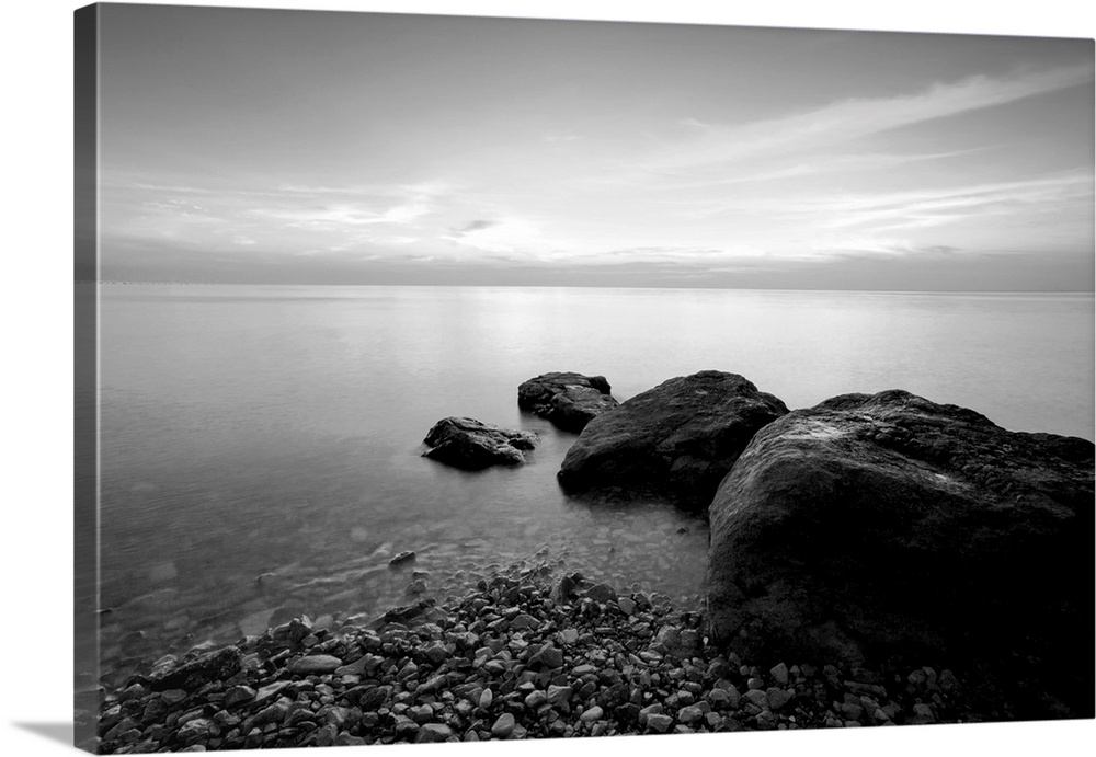 Black and white long exposure photo of beach in the evening.