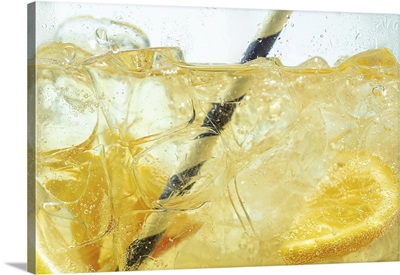 Close Up Of Lemon Slices In Stirring The Lemonade And Ice Cubes, Bubbles Fizzing