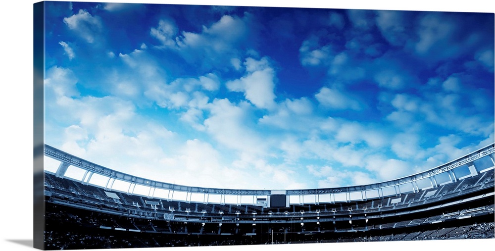 Wide Horizontal photo of a american football stadium with blue clouds in the sky.