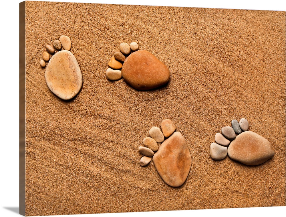 trace feet steps made of a pebble stone on the sea sand backdrop