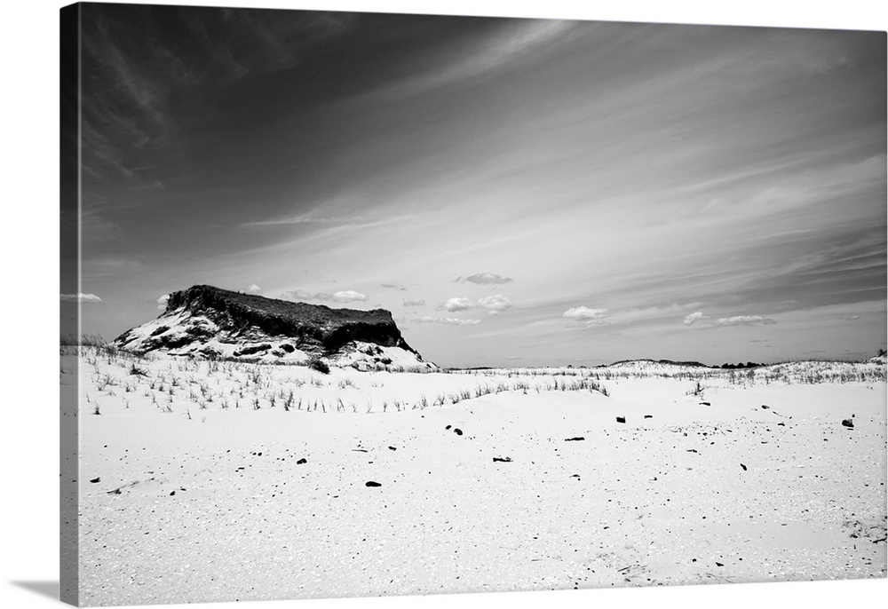 A black and white shot of a Jersey Shore sand dune against a cloud streaked sky at Island Beach State Park.