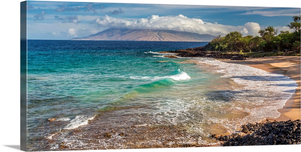 Little beach on the island of Maui, Hawaii at sunrise with turquoise sea and a view of the west maui mountains.
