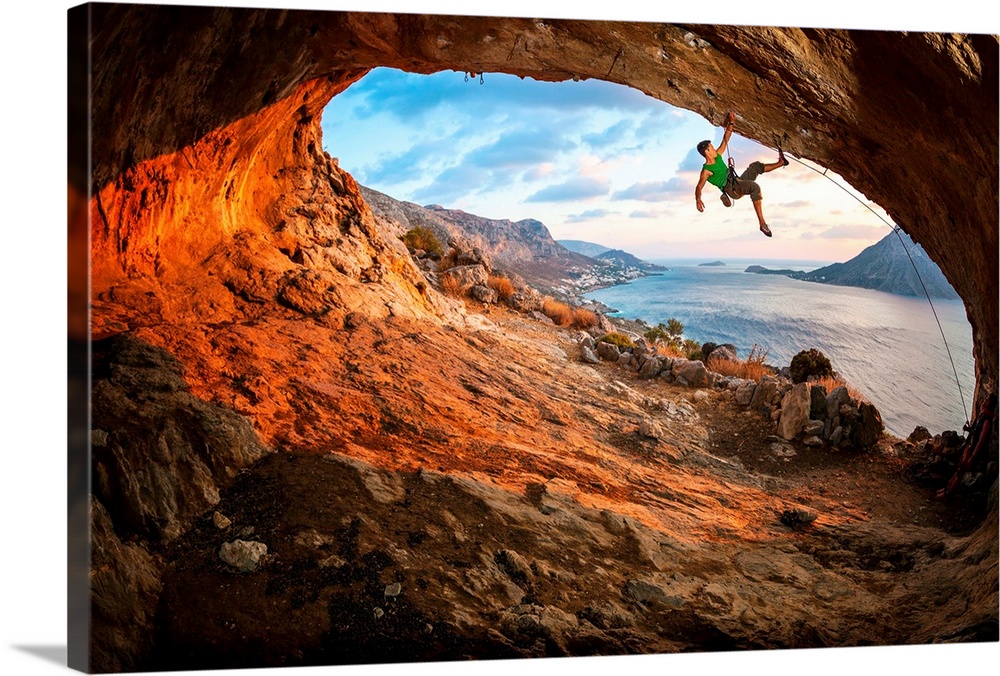 Man climbing the interior of a cave.