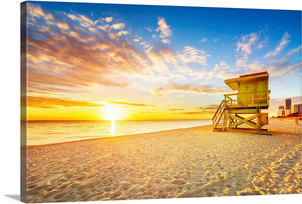Miami South Beach sunrise with lifeguard tower and coastline.