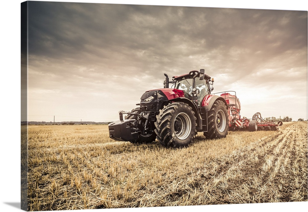 Modern red tractor seeding directly into the stubble with red equipment using GPS for precision farming in the fields of C...