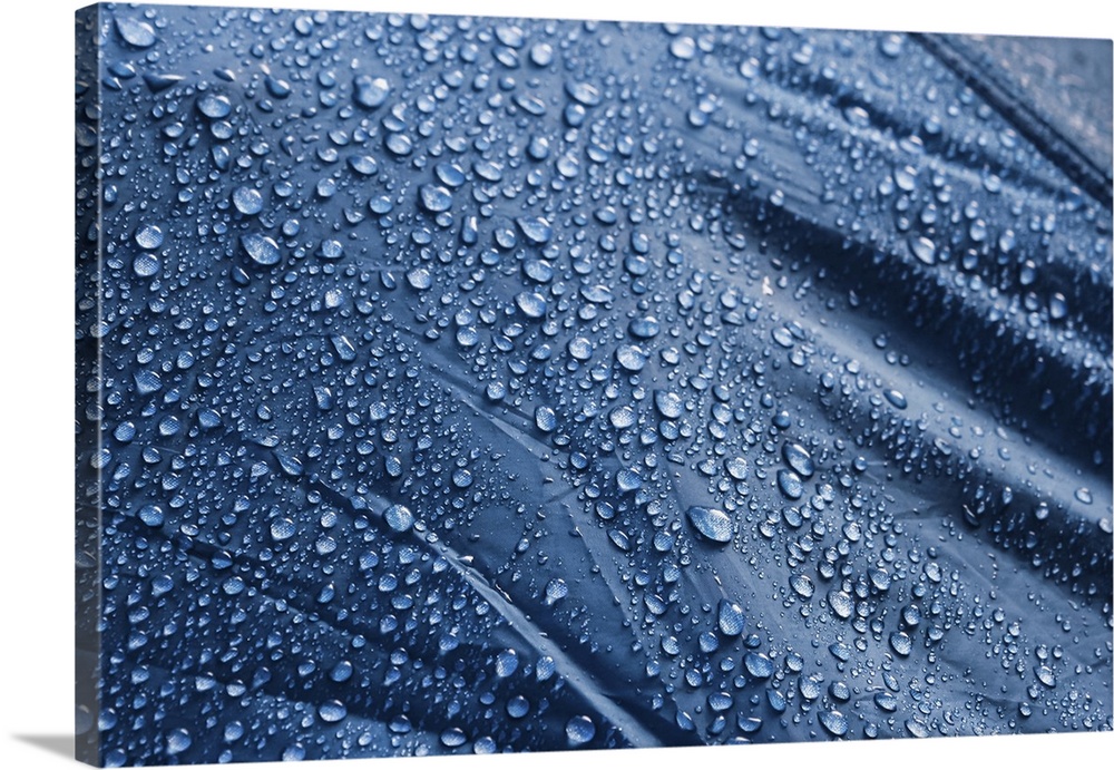 Water drops on the fabric. Rain water droplets on blue fiber waterproof fabric. Water drops pattern over a waterproof clot...