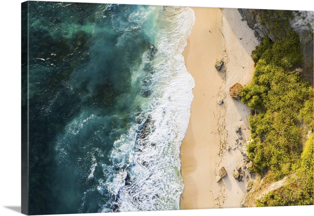 View from above, stunning aerial view of a rocky shore with a beautiful beach bathed by a rough sea during sunset, Nyang N...